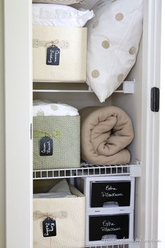 an organized closet with baskets and blankets