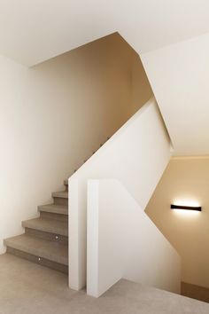 an empty room with stairs leading up to the top floor and light on either side