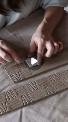 someone is carving letters out of clay