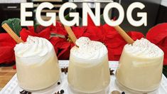 two glasses filled with whipped cream sitting on top of a white plate next to red poinsettis