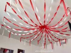 red and white streamers hanging from the ceiling in a room with pictures on the wall