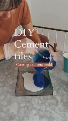 a man is pouring something into a blue cup on top of a table with the words diy cement tiles pure