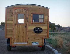 a small wooden trailer parked on the side of a road