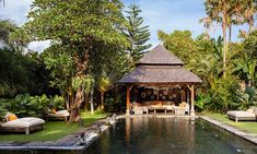 an outdoor pool surrounded by palm trees and lounge chairs, with a gazebo in the middle