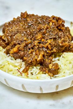 a white bowl filled with rice and meat