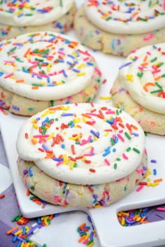 white frosted cookies with sprinkles on a plate