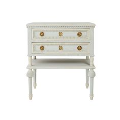 a white dresser with two drawers and gold knobs on the top, against a white background