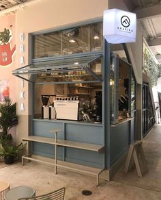 the inside of a coffee shop with tables and chairs in front of it, on display