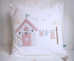 a white pillow with some clothes hanging from it's sides and a birdhouse on the other side