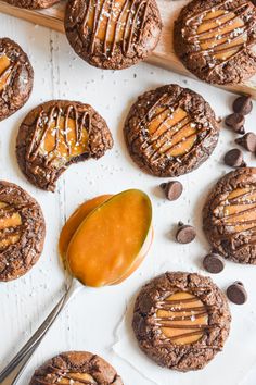 chocolate cookies with peanut butter and caramel drizzled on top, next to spoon