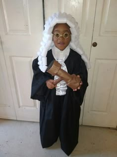 a little boy dressed up as a nun holding a piece of paper in his hands