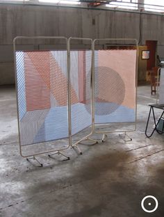 three metal screens sitting in an empty room