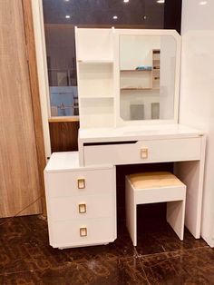 a white dressing table with drawers and a mirror