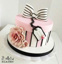 a pink and black cake with a bow on top