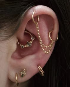 a woman wearing three different types of ear piercings