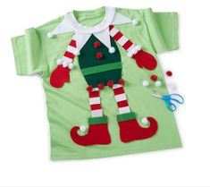 a green t - shirt with red and white striped stockings on the chest, two pairs of scissors next to it