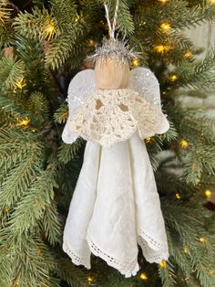 an angel ornament hanging from a christmas tree