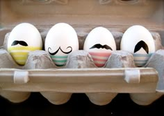 an egg carton with four eggs painted like mustaches and one is in the middle