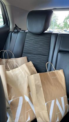 two brown bags sitting in the back seat of a car, with one bag on it's side