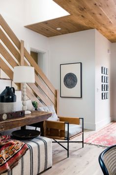 a living room filled with furniture next to a wooden ceiling mounted on the side of a wall