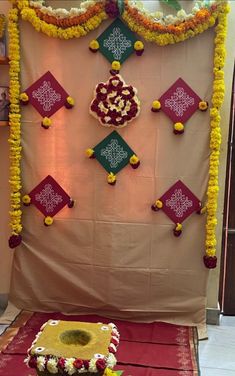 a decorated stage with flowers and decorations on the wall, along with a cake in front of it