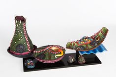 two shoes are sitting on top of a black stand and one is decorated with colorful designs