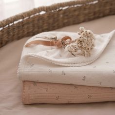 a white blanket sitting on top of a bed next to a basket