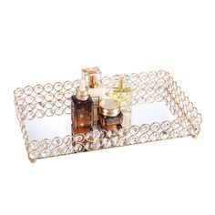 a metal tray with two bottles and some other items in it on a white surface