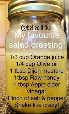 a jar filled with orange juice sitting on top of a counter