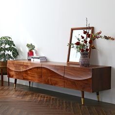 a large wooden cabinet sitting on top of a hard wood floor next to a mirror