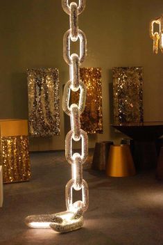 a large metal chain is in the middle of a room with gold sequins