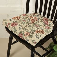 a wooden chair with a flowered cushion on it