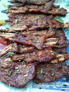 some steaks are on a blue and white plate with green sprinkles