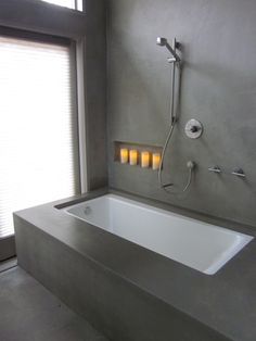 a bathroom with a bathtub and candles on the wall