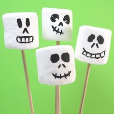 four marshmallows decorated with skulls and faces