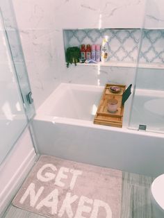 a bathroom with a bathtub, toilet and shelf filled with personal care items in it