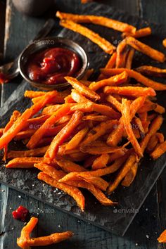 sweet potato fries with ketchup on a slate board - stock photo - images