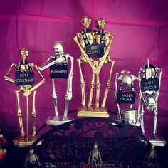 skeleton figurines on display in front of a purple backdrop