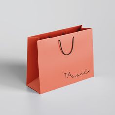 an orange shopping bag with the word tassel written on it