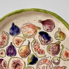 a plate that has different types of fruit on it, including figs and pears