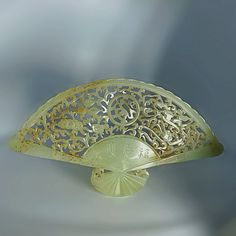 a yellow glass object with intricate designs on it