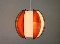 an orange and white light hanging from a ceiling