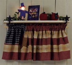 a kitchen window valance with apples and other decorations on it, hanging from a shelf