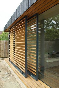 the outside of a house with wooden slats on it's sides and sliding glass doors