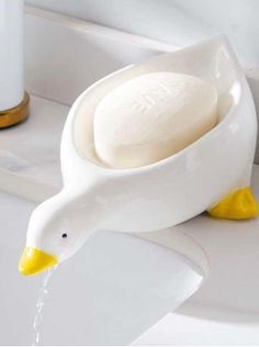 a duck shaped soap dispenser sitting on top of a sink