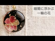 a black and red flower pendant with gold flecks on it's side