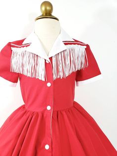 This is an adorable red (or any color) western shirt dress, with a full circles skirt and contrasting fringe and rick rack detail. I can also make it out of a different fabric or colors if you are looking for a custom cowgirl costume. This dress is shown with an underskirt that can be purchased in my shop for an additional $10. The hat is also not included but is available in my shop. https://www.etsy.com/listing/116097306/tulle-underskirt-made-to-order?ref=shop_home_active Thank you for checkin Fitted Red Fringe Dress, Fitted Red Dress With Fringe, Red Cotton Costume Dress, Western Shirt Dress, Cowgirl Dress, Tulle Underskirt, Cowgirl Dresses, Cowgirl Costume, Vintage Cowgirl