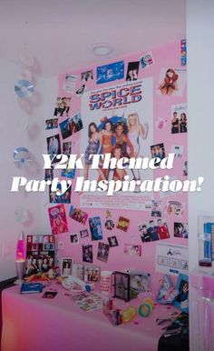 there is a pink party table with pictures on the wall and balloons in the air