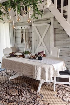 a dining room with a table and chairs in front of an open staircase leading up to the second floor