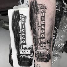 a black and white photo of the chicago theater sign on an arm by tattoo artist nathan